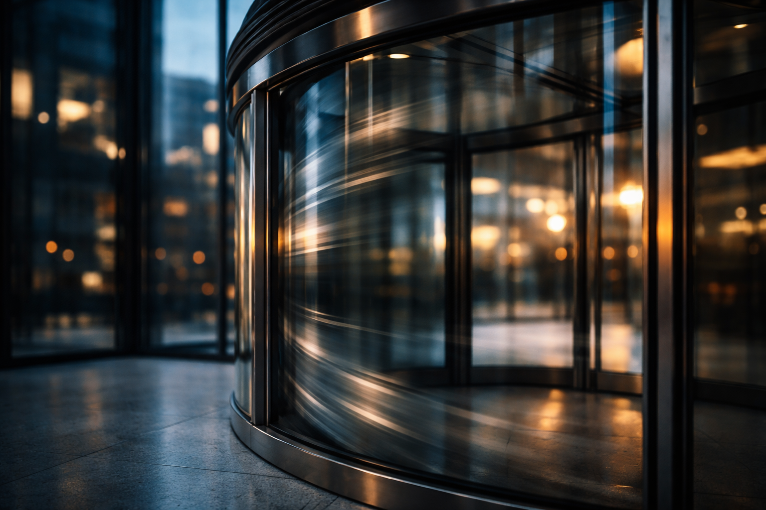 Close-up motion shot of a revolving glass entrance panel in motion, with blurred reflections on polished metal and cool dusk tones, the lower third kept calm and empty.