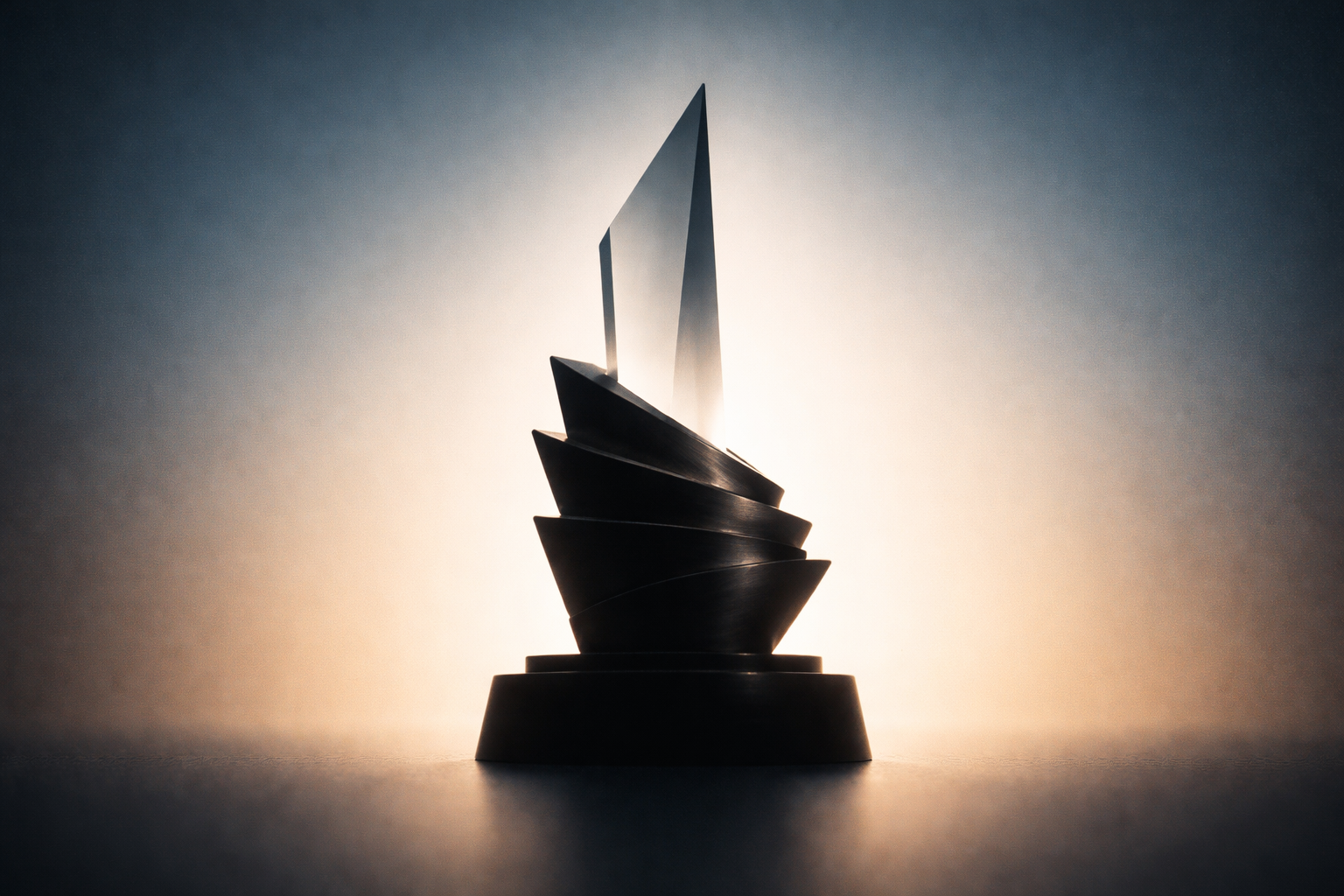 Backlit silhouette of an abstract stacked metal and frosted-glass award shape centered in the upper two-thirds against a soft blue-to-gold gradient, with the lower third intentionally clear.