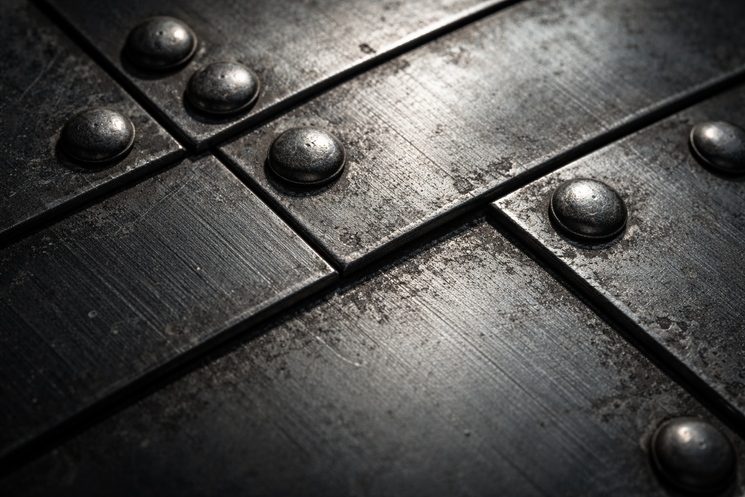 Macro photograph of industrial metal fasteners and riveted joints on a manufacturing structure, lit with raking light to highlight surface texture and geometric precision.